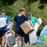 Distance shot of volunteers carrying items in for students